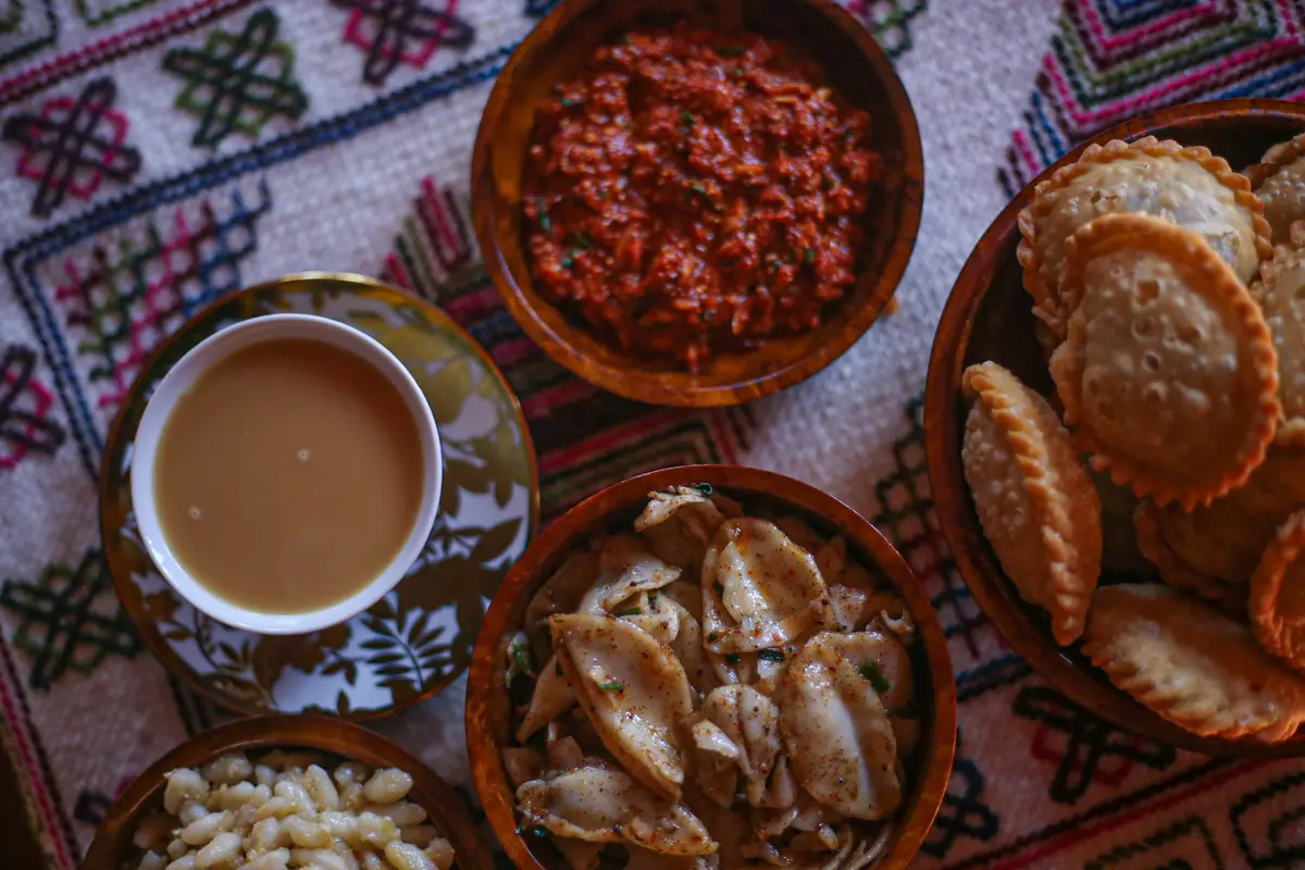 Traditional Bhutanese meal with ema datshi, red rice and seasonal vegetables served in wooden bowls
