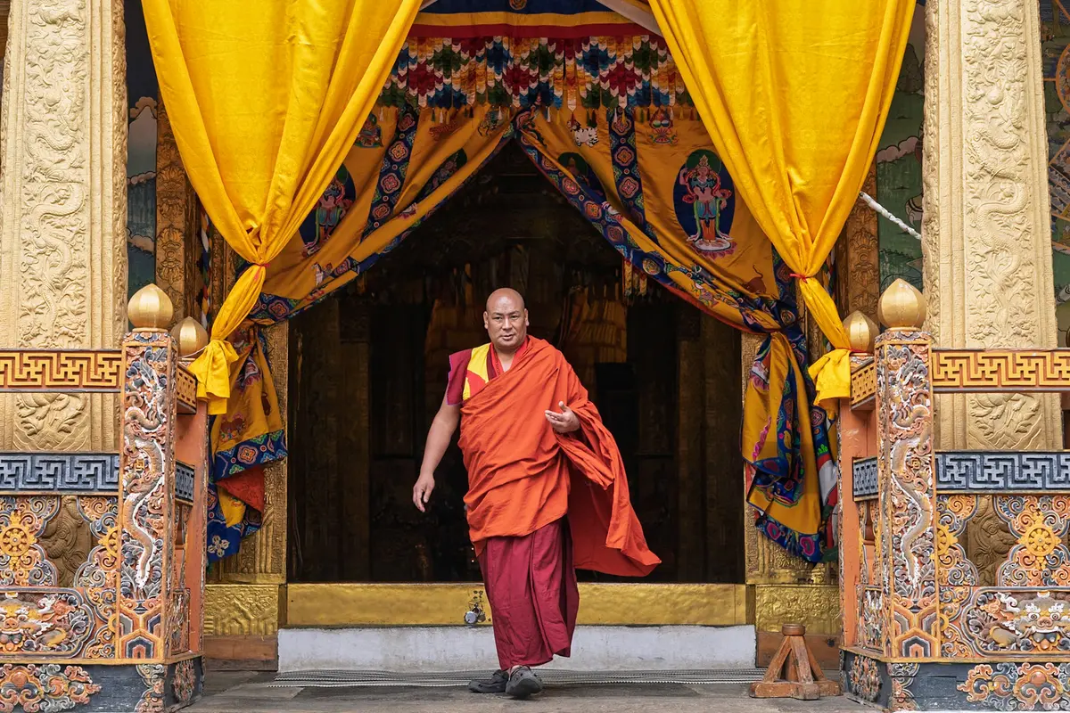 Gante Geomba monastery perched above a Bhutanese valley — its whitewashed walls and timber joinery built without iron nails in the traditional style