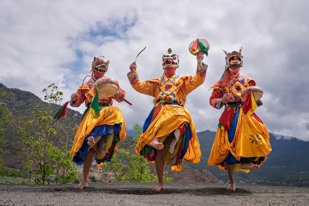 Elaborately costumed masked dancers performing at a spring Tshechu festival in Bhutan — a highlight of the March and April travel window