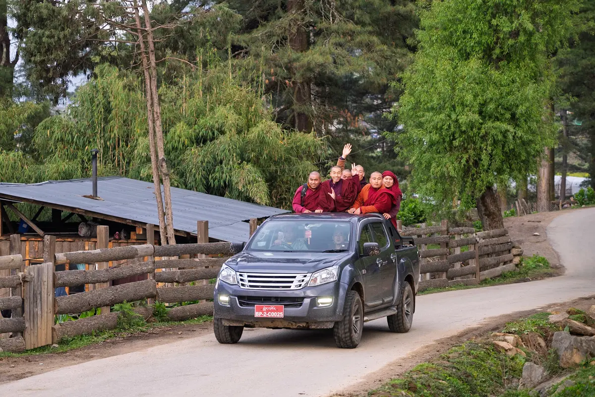Young monks on the back of a vehicle traveling between monasteries — Bhutan's Buddhist community life is inseparable from its food traditions